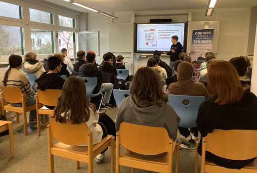 Schülerinnen und Schüler sitzen im Klassenzimmer und hören einen Vortrag