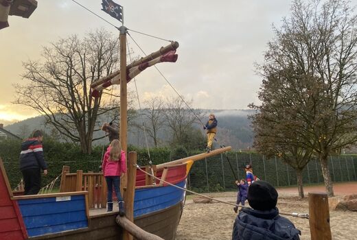 Kinder spielen auf einem großen Piratenschiff auf einem Spielplatz