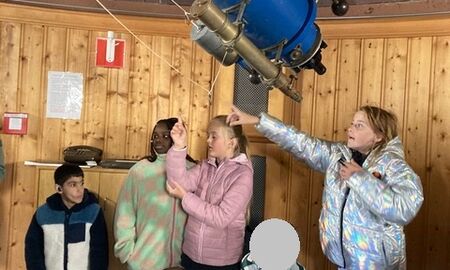 fünf Kinder schauen durch ein sehr großes Teleskop