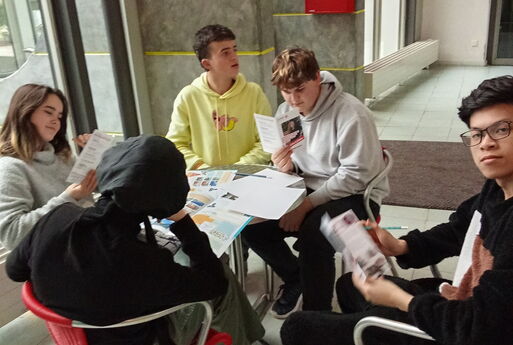 SchülerInnen schauen sich die Flyer einer Partei an.