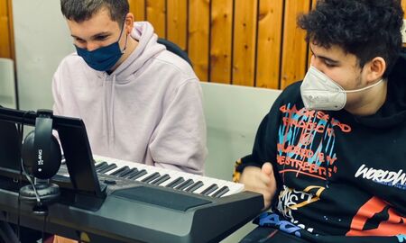 Zwei Schüler sitzen hinter einem Keyboard