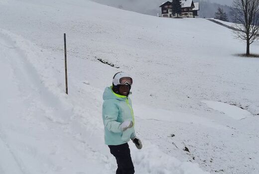 Schwarzgraue Schneelandschaft, im Vordergrund ein Snowboardfahrer