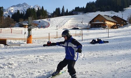 Ein Junge fährt Ski, er bremst mit dem Skipflug