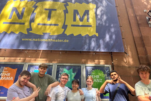 7 Schülerinnen und Schüler vor einem Plakat des NTM