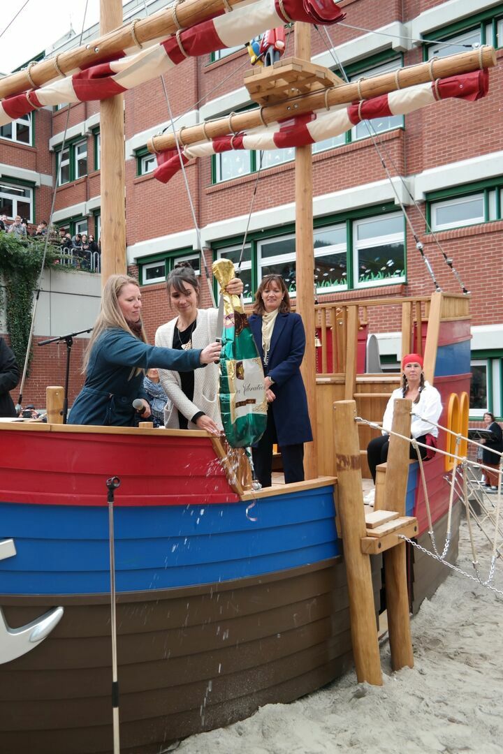 Drei Frauen führen auf dem Schiff die Schiffstaufe durch.