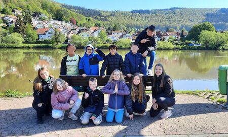 Ein Klassenfoto mit neun Schülerinnen und Schülern und beiden ISPlerinnen am Neckar.