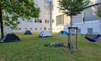 Auf einer Wiese vor dem Internat stehen Zelte
