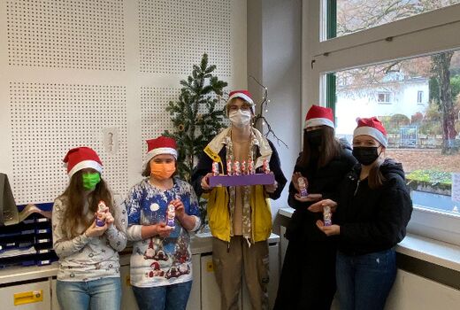 Auf dem Bild sieht man fünf Schülerinnen und Schüler der SMV mit Nikolausmützen und Schokonikoläusen.