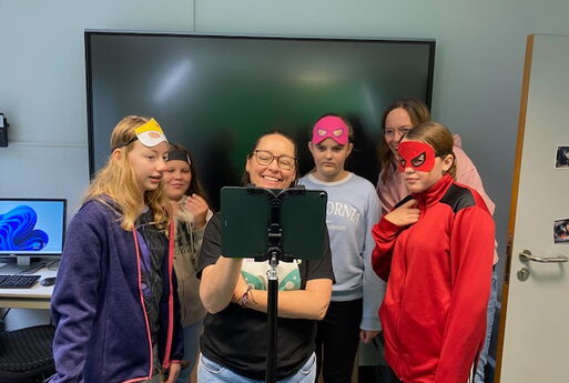 Die Kollegin aus dem MBZ zeigt den Schülerinnen und der Lehrerin das fertige Foto