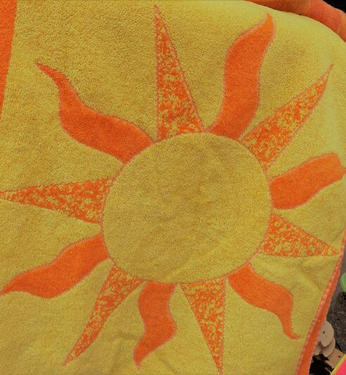 Ein gelbes Handtuch mit orangefarbener Sonne