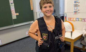 Ein Junge trägt die Polizeiweste