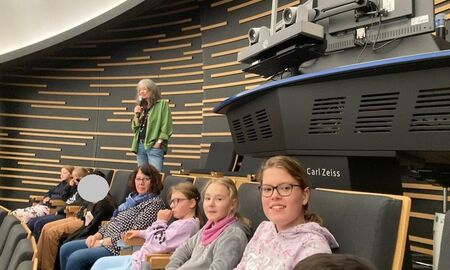 Eine Gruppe sitzt im Kinosaal des Haus der Astronomie