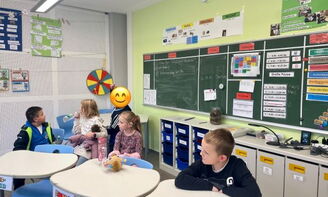 Kinder sitzen an den Tischen im Klassenzimmer