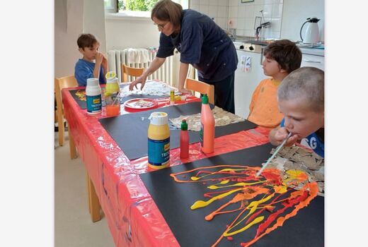 Kinder pusten mit Röhrchen FArbe aufs Bild