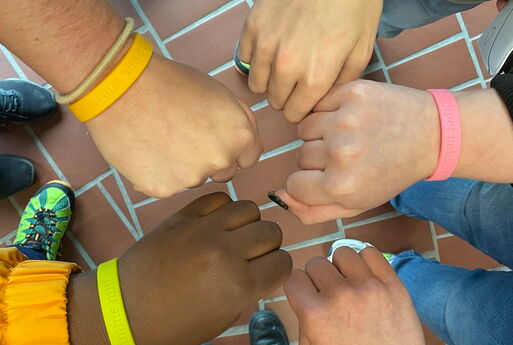 Die Schülerinnen und Schüler zeigen ihre bunten Armbänder