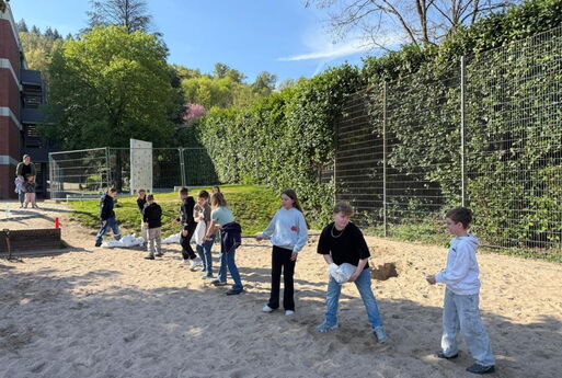 Schüler bilden eine Kette und geben Sandsäcke weiter