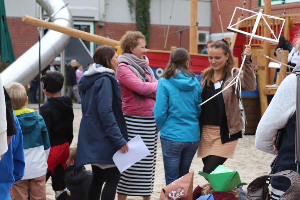 Eine Gruppe von Lehrerinnen steht zusammen. Ein von ihnen hält einen Notenständer hoch.