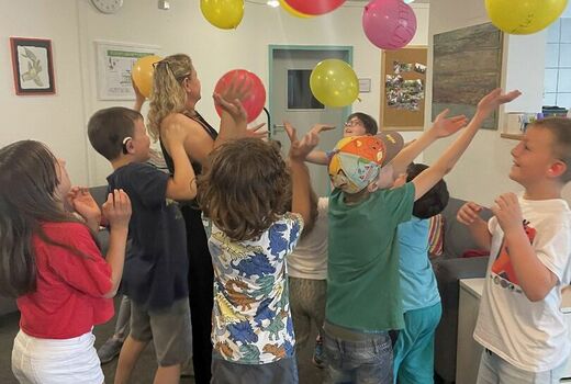 Kinder werfen Luftballons in die Höhe