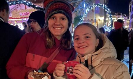 Zwei Mädchen trinken Kinderpunsch auf dem Weihnachtsmarkt