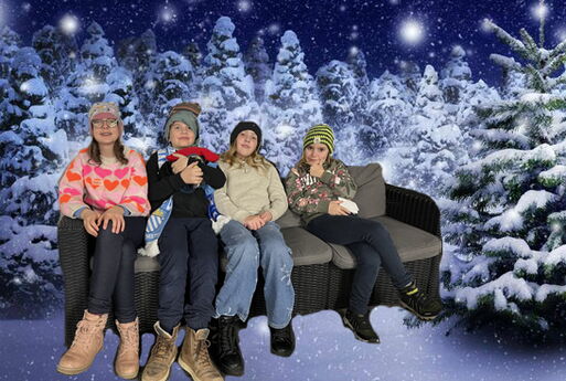 Vier Jugendliche präsentieren ihre winterliche Kopfbedeckungen. Im Hintergrund sieht man verschneite Tannenbäume. Es ist eine Fotomontage.