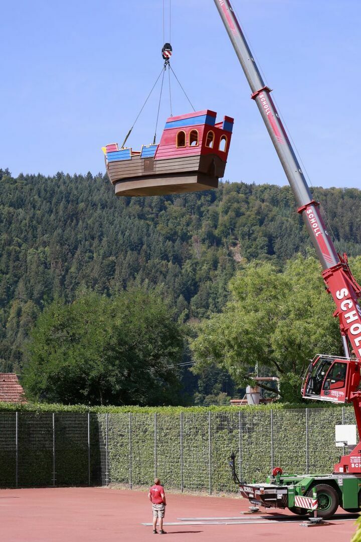 Das Playmobil-Schiff wurde mit einem Kran über die Hecke gehoben und wird nun abgelassen.