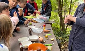 Kinder machen aus frisch geerntetem Gemüse etwas zu Essen.