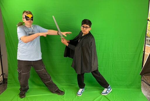 Zwei Superhelden posieren vor dem Greenscreen