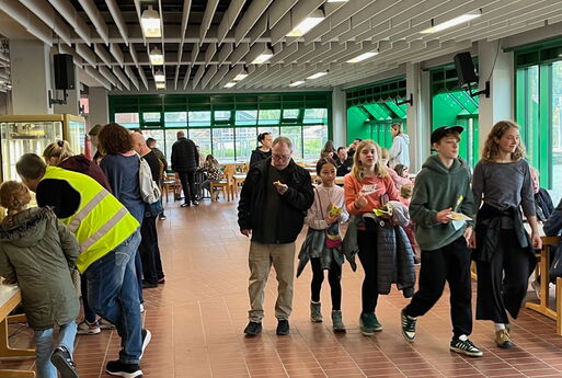 Gesamtbild in der Aula mit mehreren Menschen