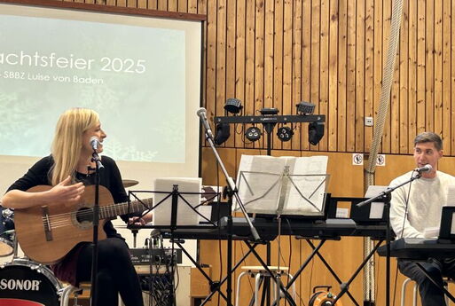 Eine Lehrerin und ein Lehrer spielen Gitarre und Klavier