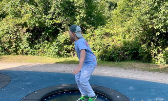 Ein Kind springt auf einem Trampolin.